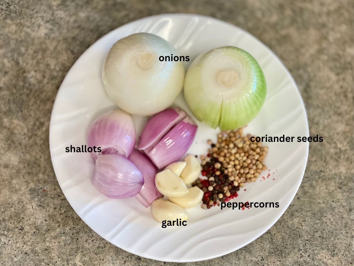 Aromatics for easy chicken broth recipe (onions, shallots, garlic, peppercorns, coriander seeds).